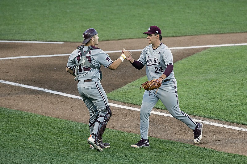AP photo by John Peterson / Mississippi State pitcher Will Bednar, right, and catcher Logan Tanner shake hands after finishing the fourth inning against Texas at the College World Series on Sunday night in Omaha, Neb.