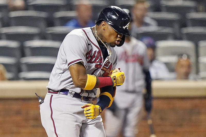 Atlanta Braves' Ronald Acuña Jr. reacts while crossing the plate after hitting a solo home run during the fifth inning of the second baseball game of a doubleheader against the New York Mets, Monday, June 21, 2021, in New York. (AP Photo/Kathy Willens)