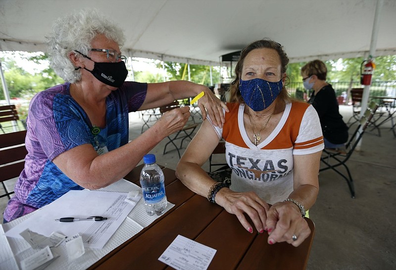 Retired RN Barbara Vicente administers a shot of the Pfizer vaccine to Bobbie Guillette, 68, from Austin, Texas, at a clinic at Mother's Brewing Company in Springfield, Mo., on Tuesday, June 22, 2021. Guillette was visiting family in Springfield a took up Mother's Brewing on their offer a free beer for getting a vaccine shot. (Nathan Papes/The Springfield News-Leader via AP)


