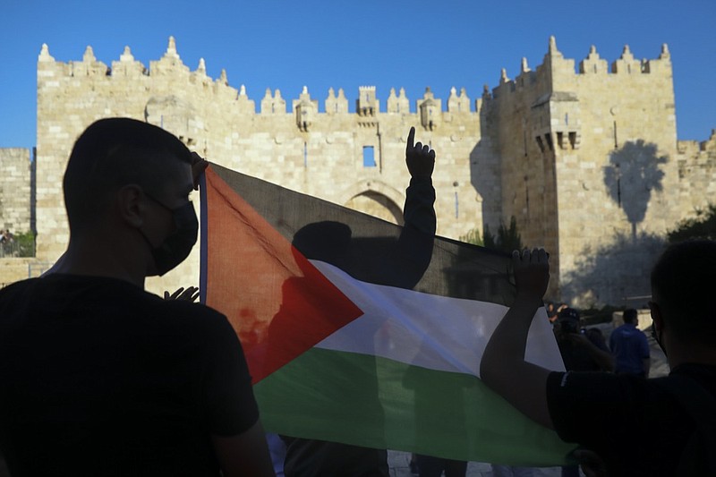 FILE - In this June 19, 2021, file photo, Palestinians demonstrators wave the Palestinian flag during protest in Damascus gate just outside Jerusalem's Old City. A new poll on U.S. attitudes toward a core conflict in the Middle East finds about half of Democrats want the country to do more to support the Palestinians (AP Photo/Mahmoud Illean, File)