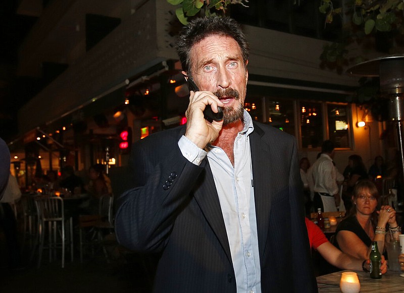 In this Dec 12, 2012 file photo, anti-virus software founder John McAfee talks on his mobile phone as he walks on Ocean Drive in the South Beach area of Miami Beach, Fla. John McAfee, the creator of the antivirus named after him, has been found dead in a cell of a jail near Barcelona, a government source told The Associated Press on Wednesday June 23, 2021 on the same day that a Spanish court issued a preliminary ruling in favor of his extradition to the United States to face tax-related criminal charges.(AP Photo/Alan Diaz, file)