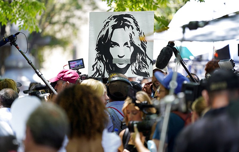 A portrait of Britney Spears looms over supporters and media members outside a court hearing concerning the pop singer's conservatorship at the Stanley Mosk Courthouse, Wednesday, June 23, 2021, in Los Angeles. (AP Photo/Chris Pizzello)