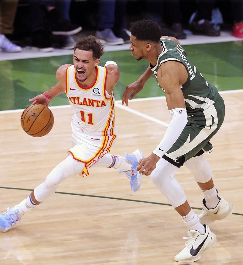 Atlanta Hawks guard Trae Young drives past Milwaukee Bucks defender Giannis Antetokounmpo during Game 1 of the NBA Eastern Conference basketball finals game Wednesday, June 23, 2021, in Milwaukee. (Curtis Compton/Atlanta Journal-Constitution via AP)