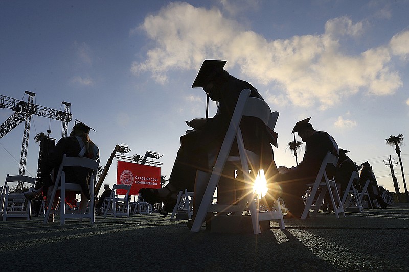 In this May 7, 2021, file photo, University of Texas Rio Grande Valley graduates sit social distanced in the early morning sunrise during their commencement ceremony at the schools parking lot in Edinburg, Texas. Repayment will restart as of Oct. 1 for 42.9 million student loan borrowers with federal debt. Vulnerable borrowers may not be ready to make payments, but there are options to find legitimate student loan help and avoid default - the consequence of missing payments. (Delcia Lopez/The Monitor via AP)