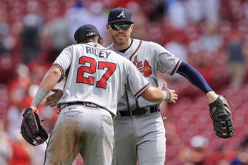 AP photo by Aaron Doster / Atlanta Braves third baseman Austin Riley hugs first baseman Freddie Freeman after the final out of the team's 4-0 win against the host Cincinnati Reds on Sunday afternoon.