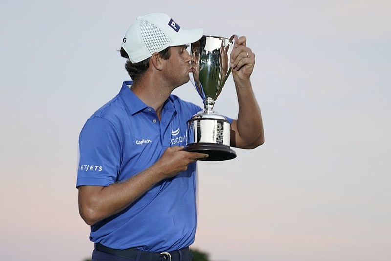 Harris English kisses the winners trophy after winning the Travelers Championship golf tournament after a playoff at TPC River Highlands, Sunday, June 27, 2021, in Cromwell, Conn. (AP Photo/John Minchillo)