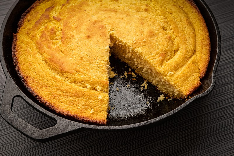 Fresh corn bread right out of the oven baked in a cast iron skillet with a slice removed. / Photo credit: Getty Images/iStock/Bruce Peter Morin