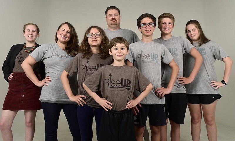 Staff Photo by Robin Rudd / Sandy Pricer and her husband, Joe, have biological and adopted former fosters who are teens, and recently started a nonprofit, RiseUp, to help equip other teens with life and leadership skills.  Pictured in the newspaper's studio are, from left, Katie, Sandy, Izzy, Joe, Nate (front), Jake, Blake and Ally. 