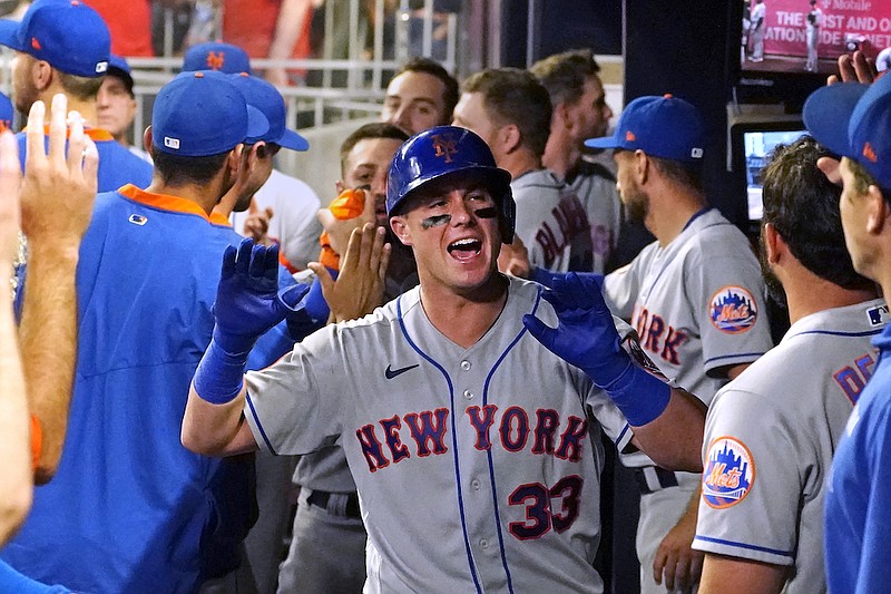 New York Mets' James McCann (33) celebrates in the dugout after hitting a three-run home run during the seventh inning of the team's baseball game against the Atlanta Braves on Tuesday, June 29, 2021 in Atlanta. (AP Photo/John Bazemore)