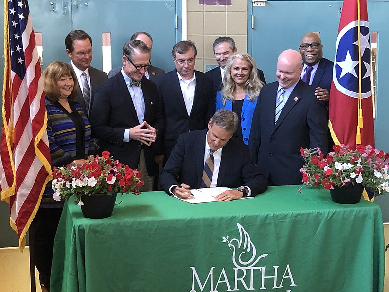 Flanked by Sen. Bo Watson, R-Hixison, (left) and Rep. Robin Smith, R-Hixson, (near right) Tennessee Gov. Bill Lee holds a ceremonial signing on Wednesday, June 30, 2021, of a law revamping the state's assistance program for impoverished families. (Photo by Andy Sher/Chattanooga Times Free Press)