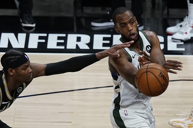 AP photo by John Bazemore / Milwaukee Bucks forward Khris Middleton, right, passes the ball as the Atlanta Hawks' Cam Reddish, left, defends during the second half of Game 6 of the Eastern Conference finals Saturday night in Atlanta.