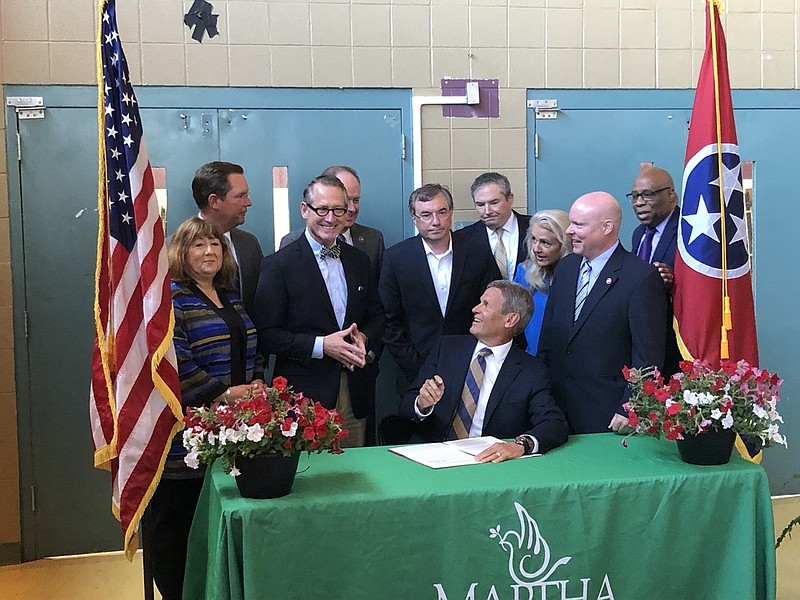 Flanked by Sen. Bo Watson, R-Hixison, (left) and Rep. Robin Smith, R-Hixson, (near right) Tennessee Gov. Bill Lee holds a ceremonial signing on Wednesday, June 30, 2021, of a law revamping the state's assistance program for impoverished families. (Photo by Andy Sher/Chattanooga Times Free Press)