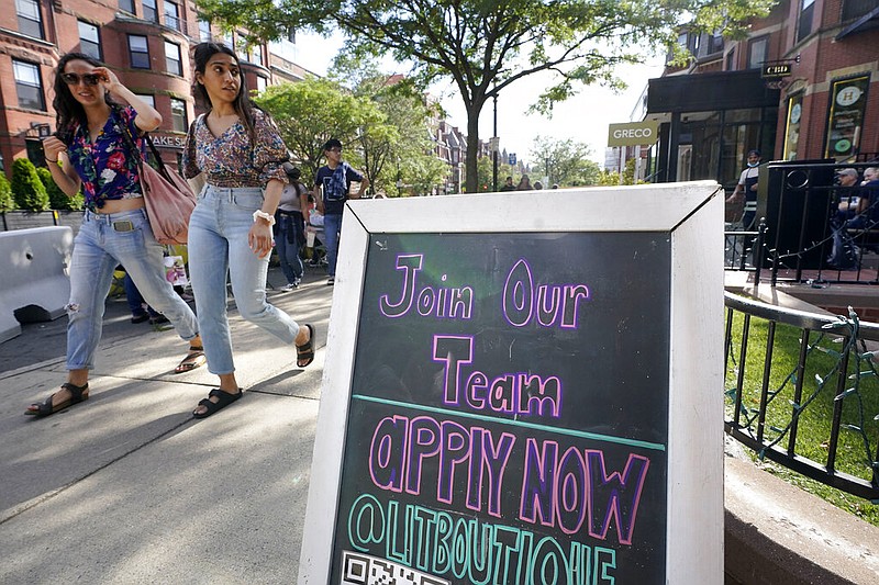 Pedestrians walk past a sign inviting people to apply for employment at a shop in Boston's fashionable Newbury Street neighborhood, Monday, July 5, 2021. As the U.S. economy bounds back with unexpected speed from the pandemic recession and customer demand intensifies, high school-age kids are filling jobs that older workers can't — or won't. (AP Photo/Steven Senne)