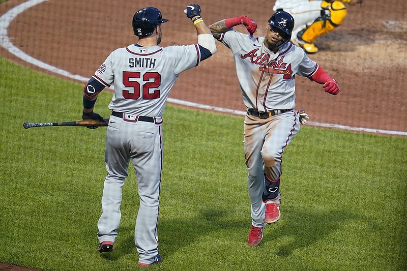 Atlanta Braves' Orlando Arcia, right, celebrates with Kevan Smith as he returns to the dugout after hitting a solo home run off Pittsburgh Pirates starting pitcher Chad Kuhl during the fifth inning of a baseball game in Pittsburgh, Tuesday, July 6, 2021. (AP Photo/Gene J. Puskar)