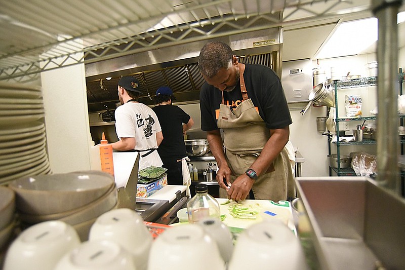 Staff Photo by Matt Hamilton / Chef Kenyatta Ashford chops peppers and tomatillos at the Proof Bar and Incubator in Chattanooga on Friday, July 9, 2021.