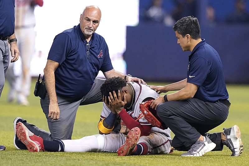 AP photo by Lynne Sladky / Atlanta Braves right fielder Ronald Acuña Jr. sits on the field after injuring his right knee while trying to make a catch during the fifth inning of Saturday's game against the host Miami Marlins.