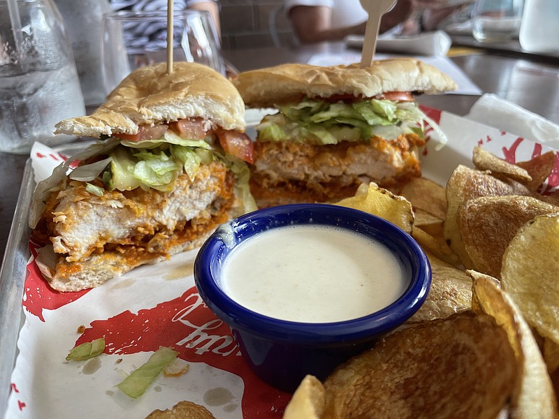Photo by Anne Braly / Rather than a French bread bun, Party Fowl's Hot Chicken Po'Boy is served on a French baguette that is sliced and served like a regular sandwich. Instead of mayonnaise or remoulade sauce, the fried chicken breast is drizzled with hot sauce.