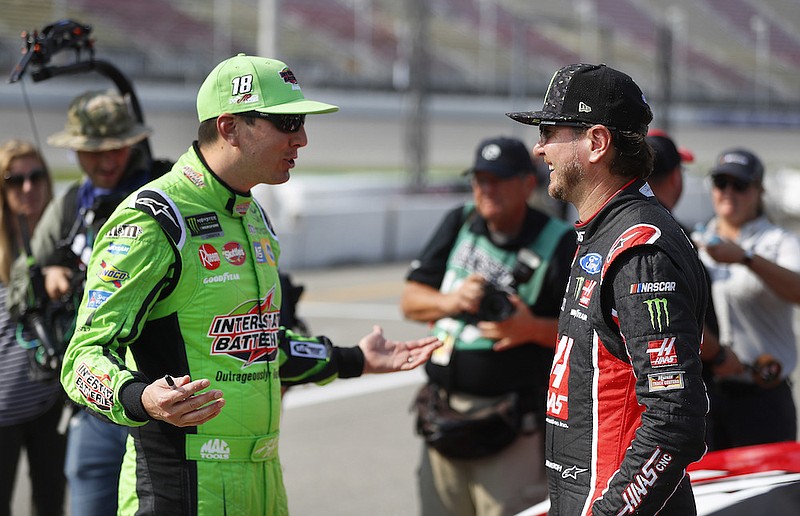 Kyle Busch, left, talks with his brother Kurt Busch before qualifications for a NASCAR Cup Series auto race at Michigan International Speedway in Brooklyn, Mich., in this Friday, Aug. 10, 2018, file photo. The Busch brothers are moving up on the Allisons on NASCAR's all-time wins list for siblings. (AP Photo/Paul Sancya, File)