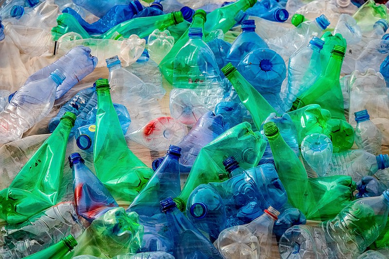 A mountain of green and blue plastic bottles that are packed and bumped tightly together. / Photo credit: Getty Images/iStock/MikeVanSchoonderwalt