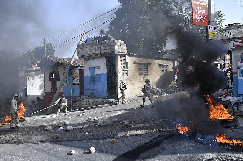 Tires burn after being set on fire by protesters upset with growing violence as police patrol and try to put out the flames and clear the road for vehicles in the Lalue neighborhood of Port-au-Prince, Haiti, Wednesday, July 14, 2021. Haitian President Jovenel Moise was assassinated on July 7. (AP Photo/Matias Delacroix)