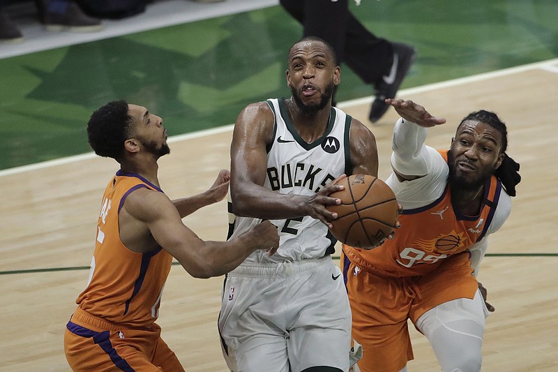 AP photo by Aaron Gash / Milwaukee Bucks forward Khris Middleton, center, drives to the basket between Phoenix Suns guard Cameron Payne, left, and forward Jae Crowder during Game 4 of the NBA Finals on Wednesday night.