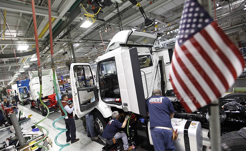 In a Jan. 6, 2011, file photo, workers install parts on a truck on the Volvo truck assembly line at the Volvo plant in Dublin, Va. Striking blue-collar workers at the Volvo heavy truck plant in southwestern Virginia narrowly ratified what the company said was its final offer in a long labor dispute, Wednesday, July 14, 2021. (AP Photo/Steve Helber, File)