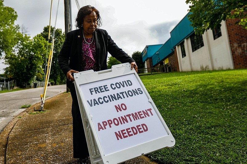 Staff photo by Troy Stolt / Mary Lambert, the new Director of Community Health for the city of Chattanooga, walks a sign that reads "Free COVID Vaccinations No Appointment Required to the corner of Moss drive and through street, just outside of Eastdale Community Center on Wednesday, July 14, 2021 in Chattanooga, Tenn. Lambert has set up an initiative to provide free COVID-19 vaccines at Community and YFD centers across the city.
