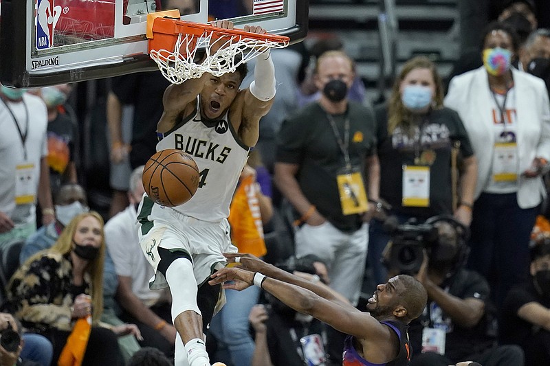 AP photo by Ross D. Franklin / Milwaukee Bucks forward Giannis Antetokounmpo dunks over Phoenix Suns guard Chris Paul during Game 5 of the NBA Finals on Saturday night in Phoenix.