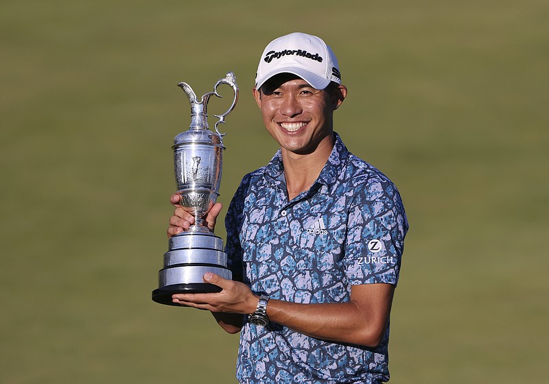 United States' Collin Morikawa holds up the claret jug trophy as he poses for photographers on the 18th green after winning the British Open Golf Championship at Royal St George's golf course Sandwich, England, Sunday, July 18, 2021. (AP Photo/Ian Walton)