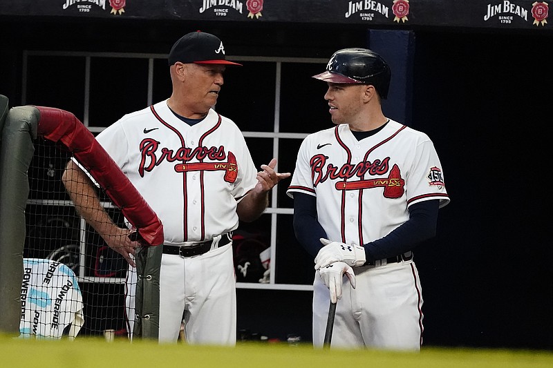 Atlanta Braves manager Brian Snitker, left, talks to first baseman Freddie Freeman during a baseball game. against the San Diego Padres Tuesday, July 20, 2021, in Atlanta. (AP Photo/John Bazemore)