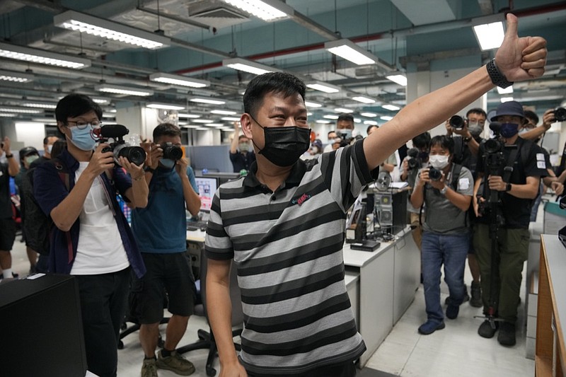 FILE - In this June 23, 2021, file photo, Lam Man-chung, center, executive editor-in-chief of Apple Daily, gestures at the headquarters before the newspaper stop publishing in Hong Kong. Hong Kong national security police on Wednesday, July 21, 2021, arrested Lam, weeks after the paper was forced to close after authorities froze its assets. (AP Photo/Kin Cheung, File)

