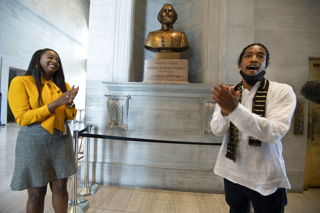 State Rep. London Lamar, left, sings with activist Justin Jones in front of the Nathan Bedford Forrest bust in the State Capitol Thursday, July 22, 2021, in Nashville, Tenn. Jones led protests over the summer of 2020 to have the bust removed. A decadeslong effort to remove the bust of the Confederate general and early Ku Klux Klan leader from the Tennessee Capitol cleared its final hurdle Thursday, with state leaders approving the final vote needed to allow the statue to be relocated to a museum. (George Walker IV/The Tennessean via AP)