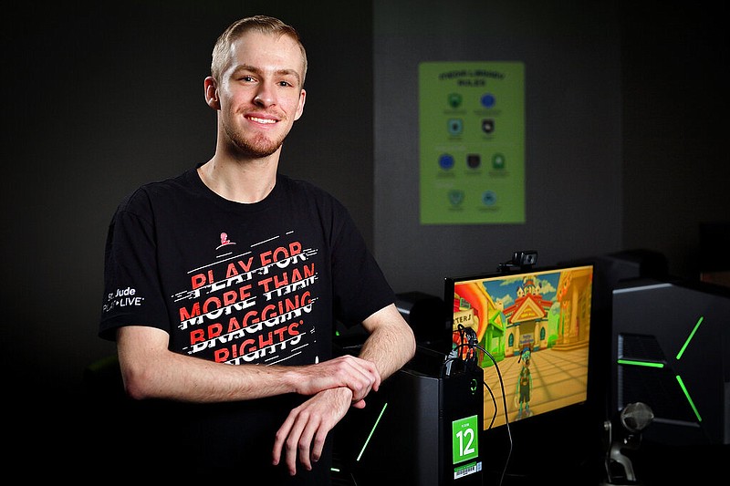 This photo provided by the University of North Texas shows student Michael Mairs in The Nest in the Media Library on the UNT campus in Denton, Texas on May 28, 2019. Mairs, 22, raises thousands of dollars for St. Jude Children's Research Hospital by playing video games online as "Smirky." (Michael Clements/UNT via AP)