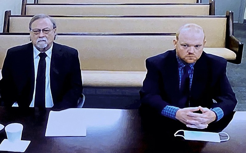 FILE - In this image made from video, from left, father and son, Gregory and Travis McMichael, accused in the shooting death of Ahmaud Arbery in Georgia on Feb. 2020, listen via closed circuit tv in the Glynn County Detention center in Brunswick, Ga., on Thursday, Nov. 12, as lawyers argue for bond to be set at the Glynn County courthouse. A judge is expected to delve into the jury selection process at a hearing Thursday, July 22, 2021, for the upcoming murder trial of three men, including the McMichaels, accused of killing Ahmaud Arbery, a Black man who was chased and shot after he was spotted running in a Georgia neighborhood. (AP Photo/Lewis Levine, File)