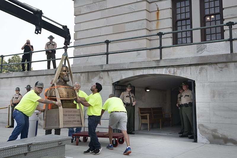 Workers remove the Nathan Bedford Forrest bust from the State Capitol as State Troopers stand guard Friday, July 23, 2021 in Nashville, Tenn. The State Building Commission on Thursday gave approval for the relocation of the Forrest bust to the Tennessee State Museum, a final step in a process that has taken more than a year since Gov. Bill Lee first said it was time for the statue to be moved. (George Walker IV /The Tennessean via AP)