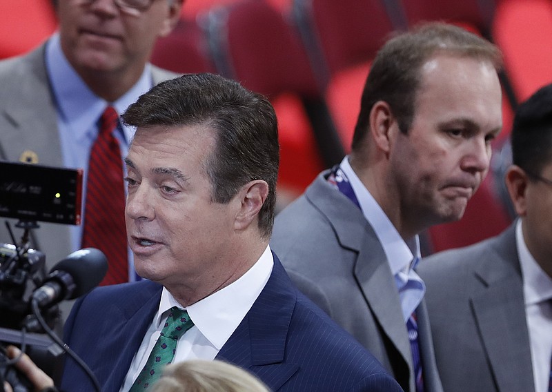 AP file photo / In this file photo from July 17, 2016, Trump Campaign Chairman Paul Manafort, and his protege Rick Gates, right, are surrounded by reporters. They are two of at least a dozen of Trump aides indicted, arrested or referred for prosecution.