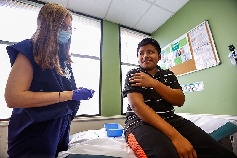 Staff photo by Troy Stolt / Joel Pedro, 13, looks at nurse practitioner Meghan Whitehead before receiving a dose of the COVID-19 vaccine at LifeSpring Community Health on Wednesday, July 21, 2021, in Chattanooga, Tenn.