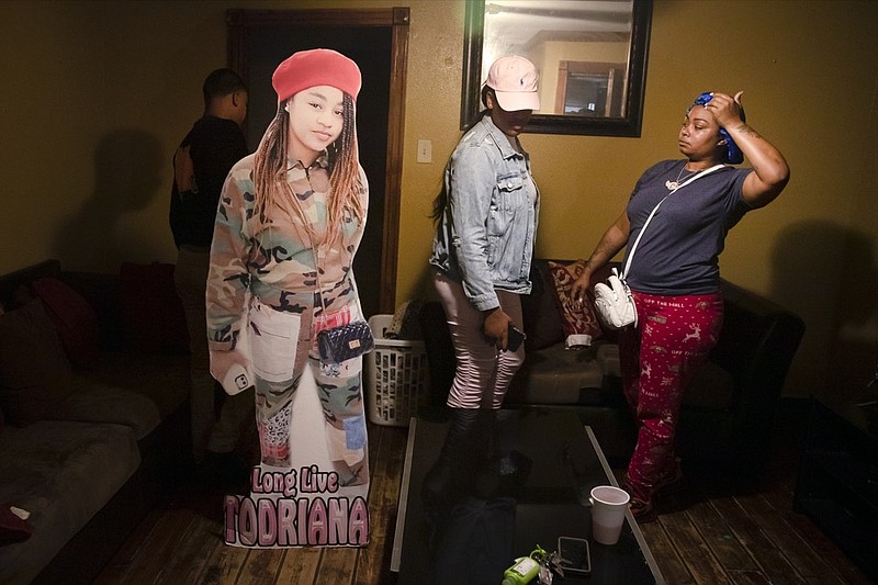 A cutout of Todriana Peters stands in her living room with her cousin Brione Rogers and mother Katrina Lambert in New Orleans, Thursday, July 8, 2021. Twelve-year-old Todriana Peters was shot and killed outside a graduation party on Memorial Day Weekend in the Lower 9th Ward neighborhood. (AP Photo/Sophia Germer)


