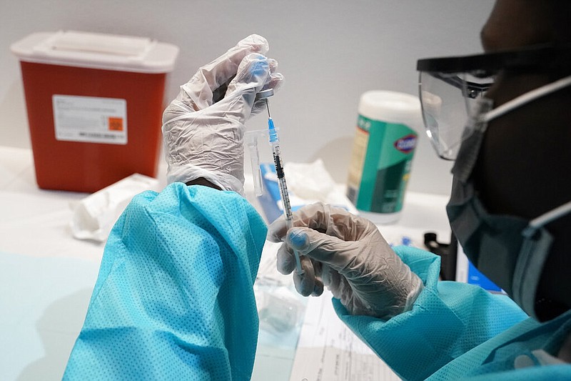 In this July 22, 2021 file photo, a health care worker fills a syringe with the Pfizer COVID-19 vaccine at the American Museum of Natural History in New York. Most Americans who haven't been vaccinated against COVID-19 say they are unlikely to get the shots and doubt they would work against the aggressive delta variant despite evidence they do, according to a new poll that underscores the challenges facing public health officials amid soaring infections in some states.(AP Photo/Mary Altaffer)