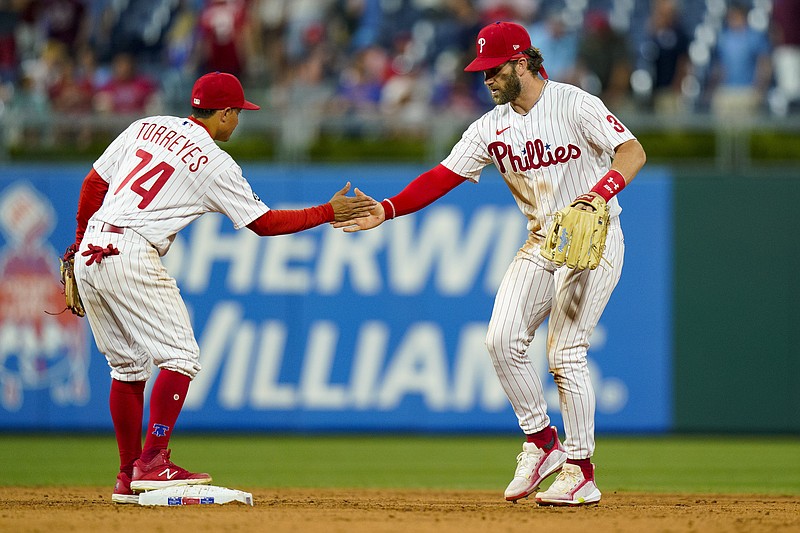 Philadelphia Phillies' Bryce Harper, right, celebrates a win with Ronald Torreyes, left, following the ninth inning of a baseball game against the Atlanta Braves, Friday, July 23, 2021, in Philadelphia. (AP Photo/Chris Szagola)