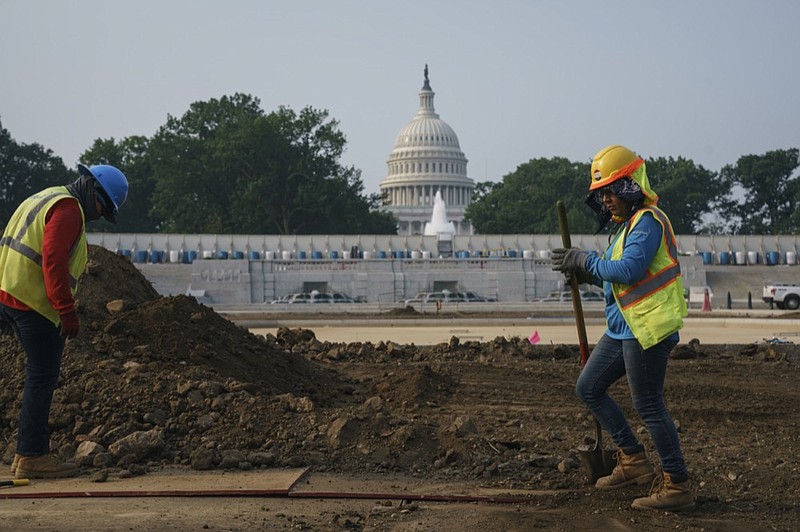 FILE - In this July 21, 2021, file photo workers repair a park near the Capitol in Washington. (AP Photo/J. Scott Applewhite, File)


