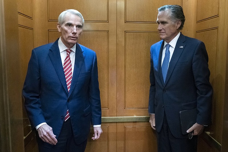 Sen. Rob Portman, R-Ohio, left, accompanied by Sen. Mitt Romney, R-Utah, leave in the elevator after a closed door talks about infrastructure on Capitol Hill in Washington Thursday, July 15, 2021. (AP Photo/Jose Luis Magana)