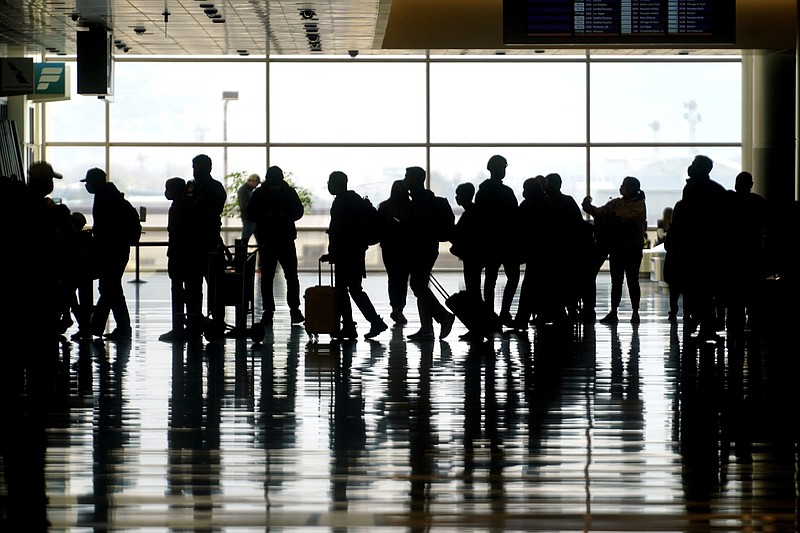 FILE - In this Wednesday, March 17, 2021 file photo, travelers walk through the Salt Lake City International Airport in Salt Lake City. Of the 2 million people clogging airport security lines and gate areas again each day, one crowd is still largely missing: business travelers. Their absence is noteworthy because they are a key source of revenue and profit, underpinning a record-breaking stretch of financial gain for U.S. airlines that ended with the coronavirus. Business travelers tend to pay higher fares, and that is especially true on international flights, which are also still deeply depressed by the pandemic and travel restrictions around the globe. (AP Photo/Rick Bowmer, file)