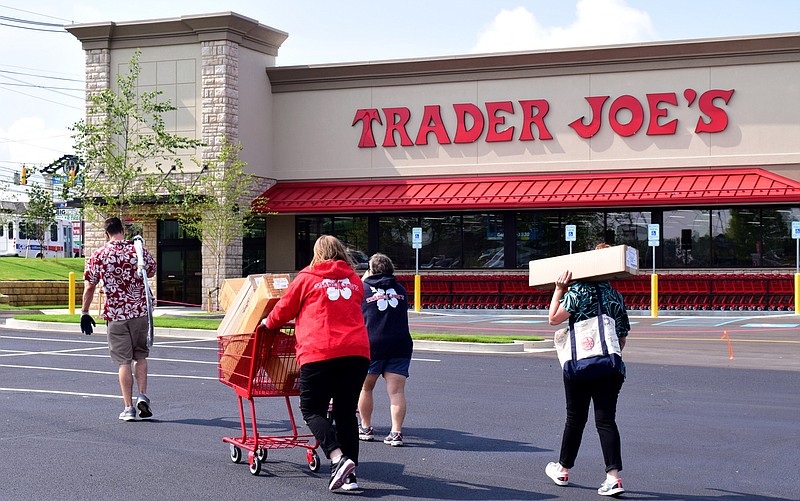 Staff Photo by Robin Rudd / Employees of the Trader Joe's carry supplies into the store across a recently sealed parking lot. The new Trader Joe's on Gunbarrel Road has its signage up as the store is nearing its grand opening.