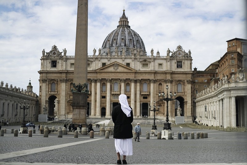 FILE - In this Sunday, March 21, 2021 filer, a nun stands in St. Peter's Square at the Vatican. Vatican prosecutors have alleged a jaw-dropping series of scandals in launching the biggest criminal trial in the Vatican's modern history, which opens Tuesday in a modified courtroom in the Vatican Museums. The once-powerful cardinal and nine other people are accused of bleeding the Holy See of tens of millions of dollars in donations through bad investments, deals with shady money managers and apparent favors to friends and family. (AP Photo/Gregorio Borgia, File)