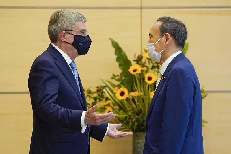 FILE - In this July 14, 2021, file photo, International Olympic Committee President Thomas Bach, left, meets Japanese Prime Minister Yoshihide Suga during his courtesy call at the latter's official residence in Tokyo. How are we to judge the pandemic-delayed Tokyo Olympics when they wrap up in two weeks? It's a straightforward question but it's difficult to answer. That's because there are many interests involved. (Kimimasa Mayama/Pool Photo via AP, File)