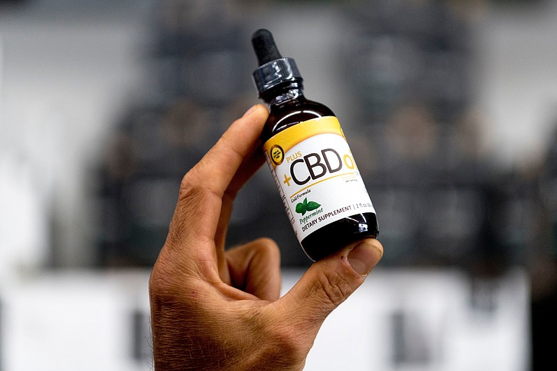 General Manager Mike Wright holds a bottle of CBD oil which is sold at Eddie's Health Shoppe in Suburban Plaza in West Knoxville, Tennessee on Thursday, July 26, 2018. CBD, one of 104 chemical compounds found in cannabis, has been gaining popularity recently for its pain and anxiety relieving properties