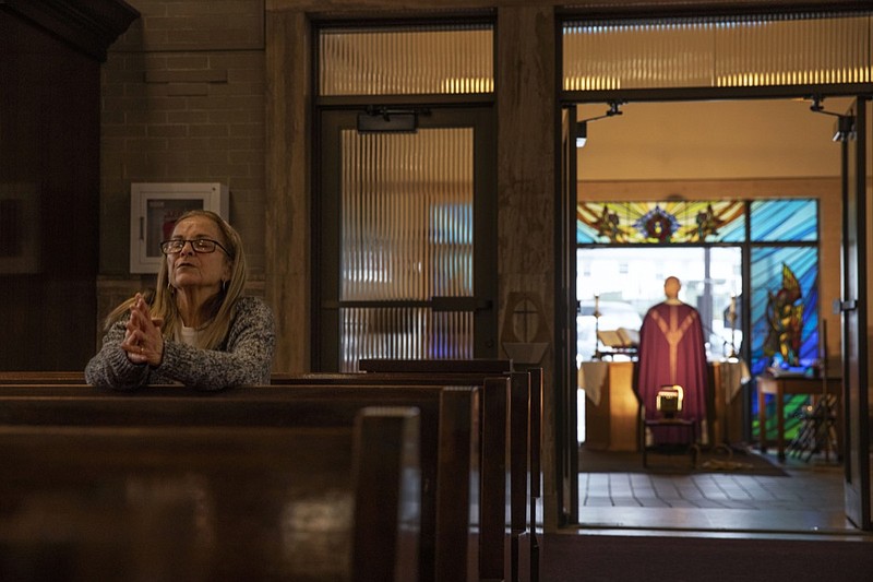 FILE - Fran DiBiasio sits alone in Our Lady of Grace Catholic Church as Rev. Peter Gower celebrates Mass from the front door as worshippers listen over the radio from their cars in the parking lot, Sunday, March 29, 2020, in Johnston, R.I. For the first time in nearly two decades, only half of U.S. households donated to a charity, according to a study released Tuesday, July 27, 2021. Experts say many factors are contributing to the decline. The percentage of Americans who give to religious causes has decreased in tandem with attendance at worship services as the number of Americans not affiliated with any religion grows. (AP Photo/David Goldman, File)