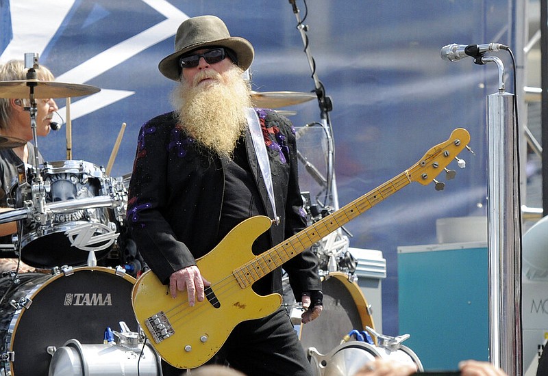 Dusty Hill, of ZZ Top, performs before the start of the NASCAR Sprint Cup series auto race in Concord, N.C., May 24, 2015. ZZ Top has announced that Hill, one of the Texas blues trio's bearded figures and bassist, has died at his Houston home. He was 72. In a Facebook post, bandmates Billy Gibbons and Frank Beard revealed Wednesday, July 28, 2021, that Hill had died in his sleep. (AP Photo/Mike McCarn, File)
