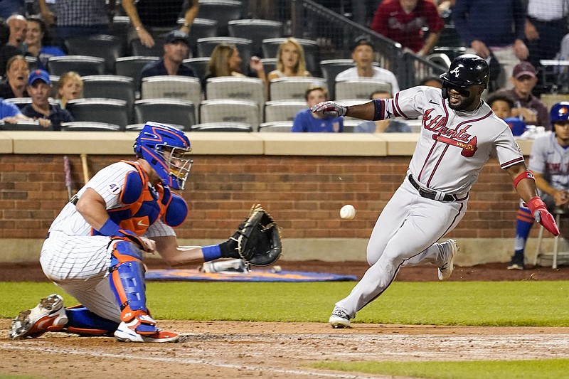 AP photo by Mary Altaffer / New York Mets catcher James McCann prepares to tag out the Atlanta Braves' Abraham Almonte as he tries to score on a pinch hit by Ehire Adrianza during the ninth inning of Wednesday night's game in New York.